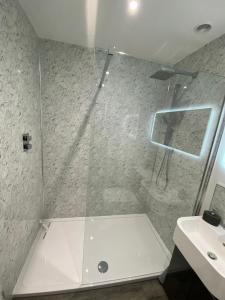 a shower with a glass door next to a sink at Comfortable Apartment set in an Old Mill in Westbury +23 photos