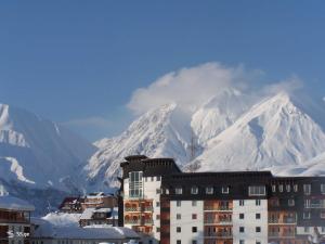 a building in front of a mountain with snow at Axis in Kʼumlistsʼikhe