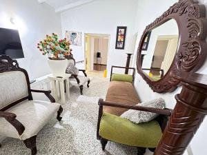 a living room with chairs and a mirror at Casa Lucy Alojamientos in Palmira