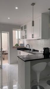 a kitchen with white cabinets and a black counter top at Casa Ventura in Lagos