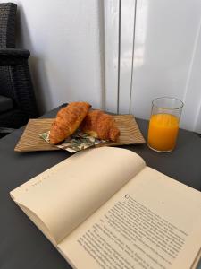 two croissants and an open book on a table with an open book at Casa Ventura in Lagos
