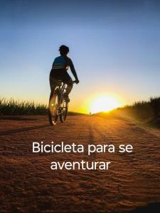 a person riding a bike down a dirt road at sunset at Hospedaria LARENA in Florianópolis