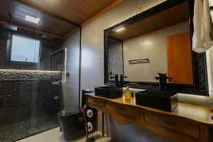 ein Badezimmer mit zwei Waschbecken und einer Dusche mit Spiegel in der Unterkunft Piemonte chalé in Casca