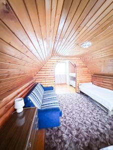 a room with a bed in a wooden room at Anetes pirts in Jaunanna +4 photos