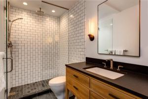 a bathroom with a sink and a toilet and a mirror at Abode at Rendezvous in Teton Village +27 photos