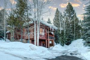 a log cabin in the snow with snow covered trees at Abode at Moose Creek #21 in Teton Village