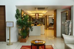 a lobby of an office with a table and a counter at KGA Elite Continental Hotel in Thiruvalla