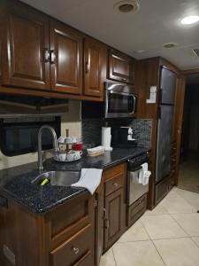 a kitchen with wooden cabinets and a sink and refrigerator at Tiki Cabana at Key Largo in Key Largo