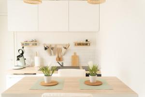 a kitchen with a table with two plants on it at Les secrets d hedoné in Nogna +23 photos