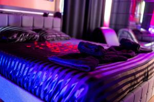 a bed with purple lights on top of it at Les secrets d hedoné in Nogna