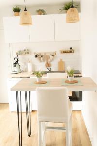 a kitchen with a table and two white chairs at Les secrets d hedoné in Nogna