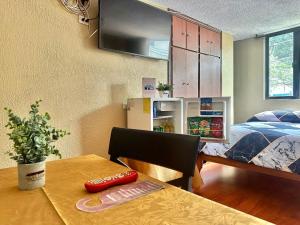 a small room with a table and a bed at Hostal La Estación Quito in Quito