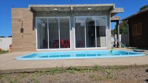 a swimming pool in front of a house at Casa com três quartos, piscina e área Gourmet in Torres