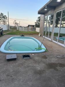 a large turquoise pool in a driveway at Casa com três quartos, piscina e área Gourmet in Torres