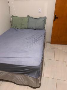 a bed with two pillows on it in a room at Casa com três quartos, piscina e área Gourmet in Torres +9 photos