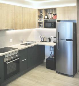 a kitchen with a stainless steel refrigerator and a sink at Lujoso Departamento con Garage in Caña de Castilla