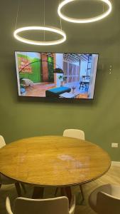 a conference room with a wooden table and a tv on the wall at Lujoso Departamento con Garage in Caña de Castilla