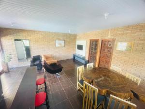 a living room with a wooden table and chairs at Chácara Com Piscina e Vista das Montanhas in Atibaia