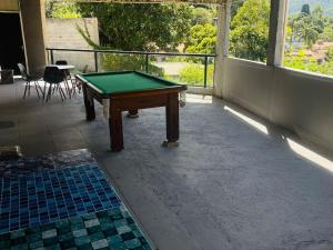 a pool table sitting on top of a balcony at Chácara Com Piscina e Vista das Montanhas in Atibaia