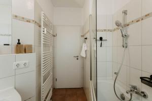 a white bathroom with a shower and a tub at Designer Loft am Dessauer Hauptbahnhof in Dessau +29 photos