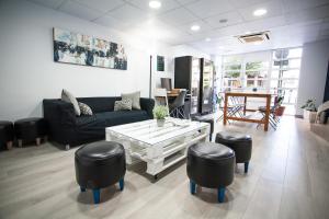 a living room with a couch and a table and stools at Hotel Universal Murcia in Murcia