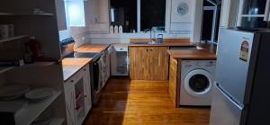 a kitchen with a refrigerator and a washing machine at Spacious big sea views star bath in Paihia +16 photos