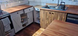 a kitchen with a sink and a wooden floor at Spacious big sea views star bath in Paihia