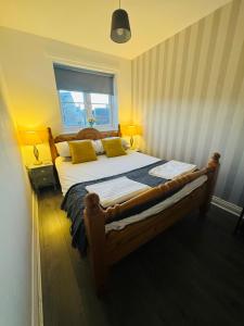 a bedroom with a large wooden bed with yellow pillows at The Woodlands 3bed 2bath in Langley Park