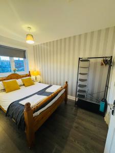 a bedroom with a large bed with yellow pillows and a ladder at The Woodlands 3bed 2bath in Langley Park