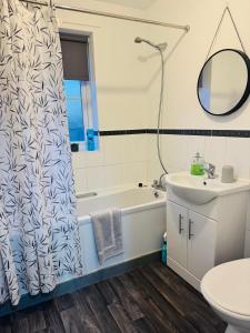 a bathroom with a tub and a sink and a toilet at The Woodlands 3bed 2bath in Langley Park