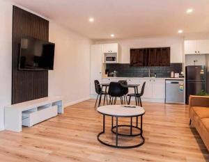 a kitchen and living room with a table and chairs at Lagoon Apartments in Nuku‘alofa