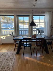 a dining room with a table and chairs and windows at Fjällstuga Vemdalsskalet in Vemdalen +13 photos