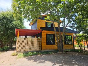 a small yellow house with a tree in front of it at Las Victorias in Salto del Laja
