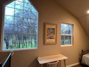 a bedroom with two windows and a wooden table at Montgomery Apartment in Redding