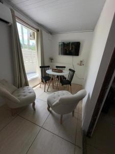 a living room with a table and chairs and a window at Moramay 2 in Punta del Este