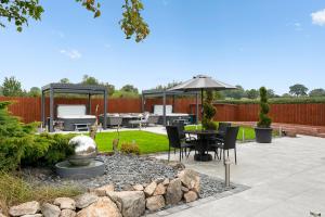 a patio with an umbrella and a table and chairs at Blacksmiths Cottage by Birch Stays in Needwood