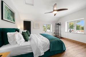 a bedroom with a bed and a ceiling fan at Blacksmiths Cottage by Birch Stays in Needwood