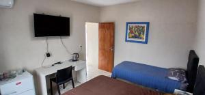 a room with a bed and a desk with a television at Tempo Suites in Córdoba