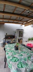 a table with a green and white table cloth with a plant on it at Tempo Suites in Córdoba