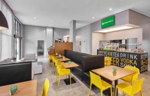 a restaurant with yellow tables and yellow chairs at Nacional Inn Palmas in Palmas