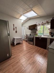 a kitchen with a wooden floor and a large window at Quinta Los 3 Tesoros in San Francisco Amatepe +4 photos