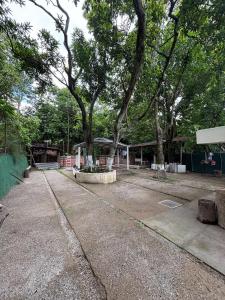 a park with trees in front of a building at Quinta Los 3 Tesoros in San Francisco Amatepe