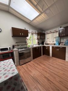 a kitchen with brown cabinets and a wooden floor at Quinta Los 3 Tesoros in San Francisco Amatepe