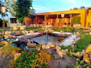 a garden with a pond in front of a house at Seven B&b in Casalmorano