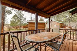 a wooden deck with a table and chairs on a porch at Hike, Fish & Enjoy Pond On-Site: Bison Ranch Cabin in Overgaard