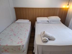 two beds in a small room withskirts at Loft Juquehy in São Sebastião