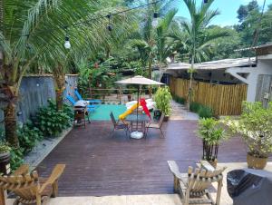 a patio with a table and umbrella and a pool at Loft Juquehy in São Sebastião