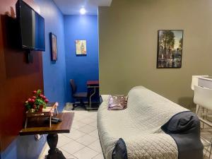 a living room with a couch and a tv at Horus Suite Apartamento in San Pedro Sula
