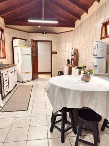 a kitchen with a table with a white table cloth on it at Pousada Vivenza - Suíte Super Confort 01 in Laguna