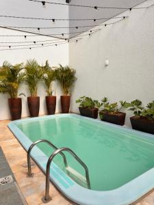 a hot tub in a room with potted plants at Pousada Vivenza - Suíte Super Confort 01 in Laguna